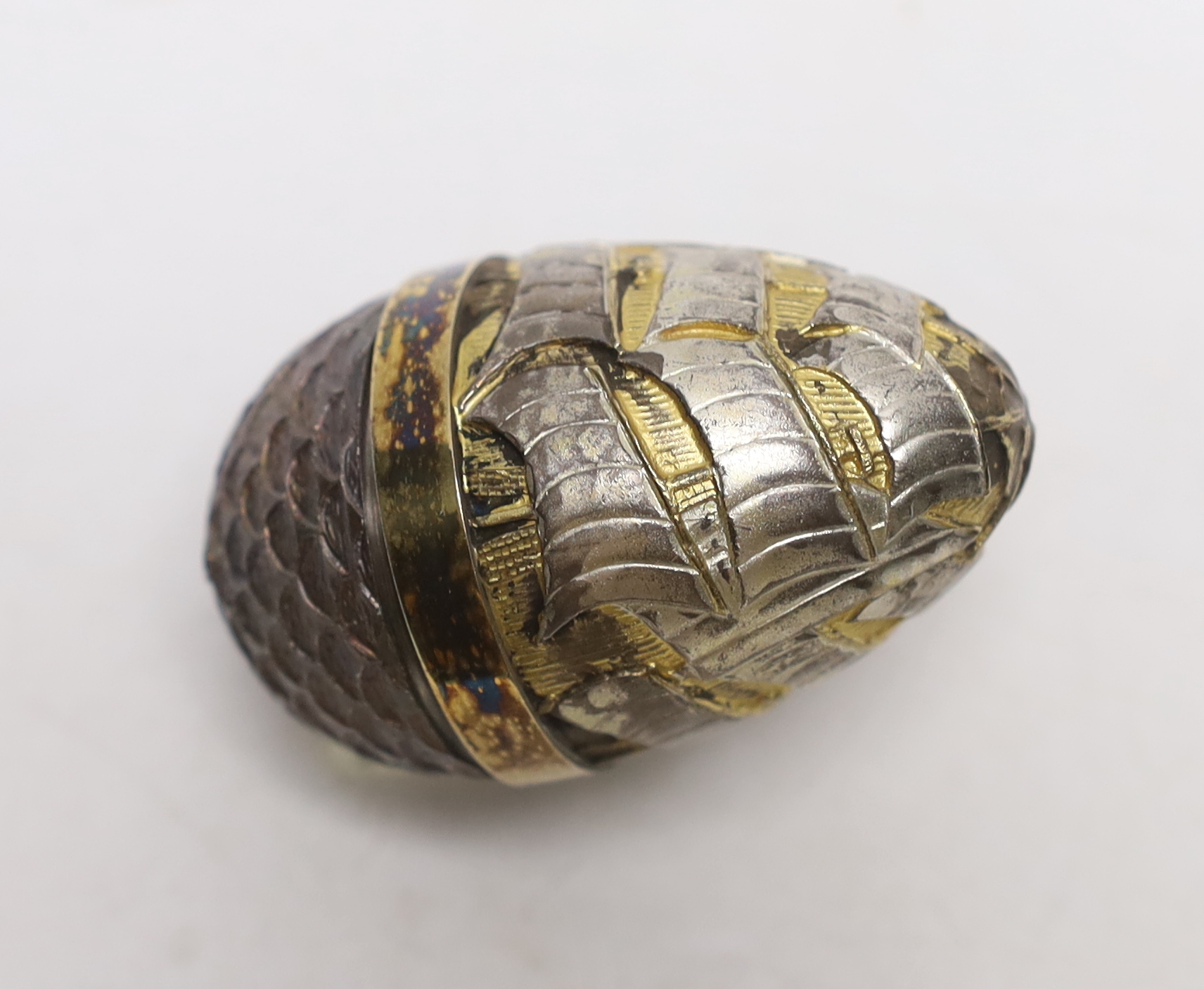 An Elizabeth II parcel gilt silver and enamel surprise egg, by Stuart Devlin, London, 1989, numbered 20, opening to reveal sailing yachts, 6x6mm.